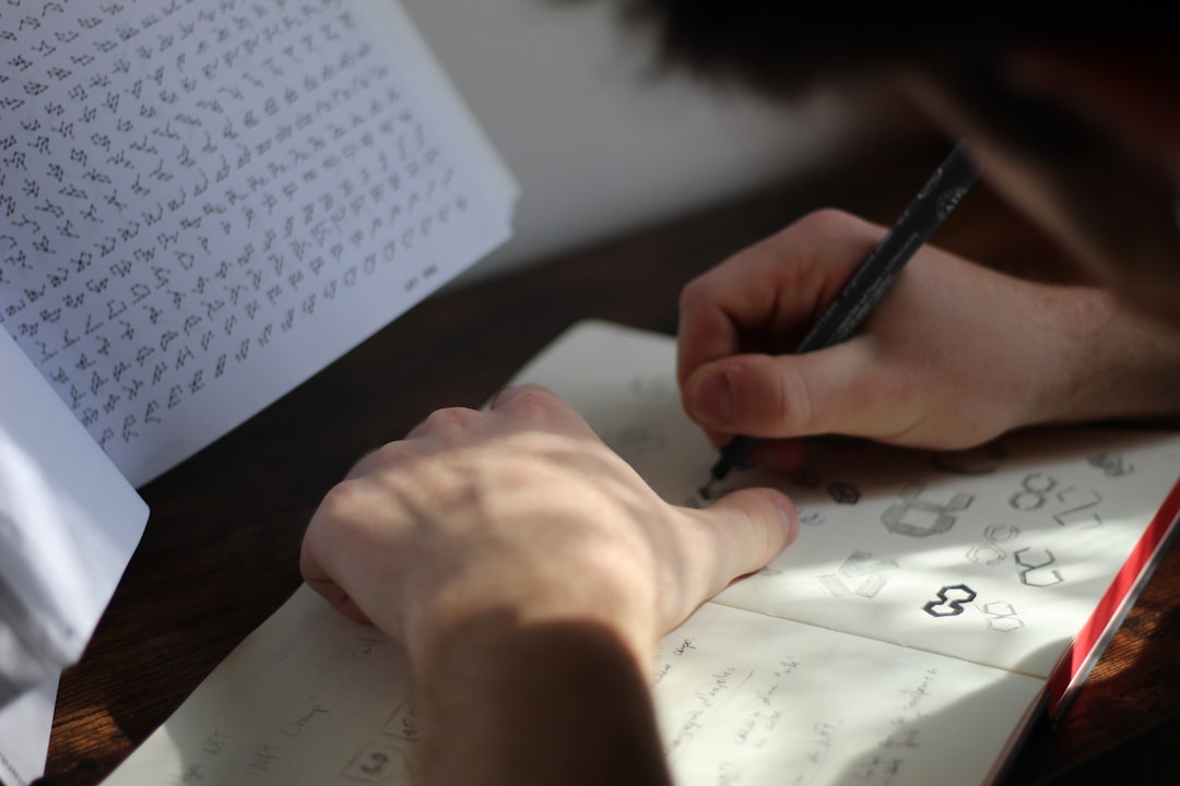 Man scribbling logo design on a wooden desk.